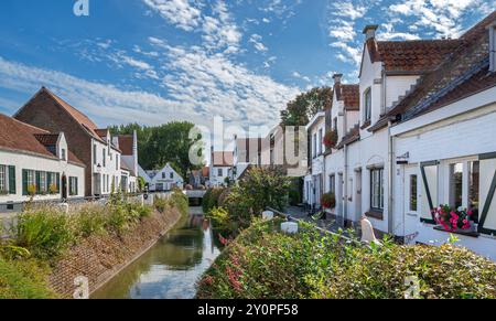 Case bianche lungo il Lisseweegs Vaartje, piccolo canale che attraversa il villaggio di Lissewege vicino a Bruges in estate, Fiandre occidentali, Belgio Foto Stock