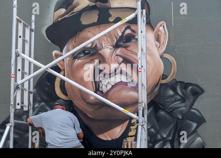 Southend City Jam 2024 Street graffiti, evento che si svolge a Southend on Sea, Essex, Regno Unito. Una caricatura in stile rapper arrabbiato che viene dipinta Foto Stock