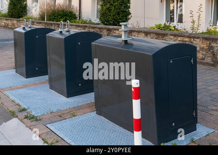 Tre contenitori in metallo grigio per la raccolta differenziata dei rifiuti sul marciapiede della città. Foto Stock