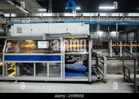 Moderna linea di produzione automatizzata di imbottigliamento di bevande in bottiglie di plastica. Foto Stock