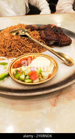 Ritratto a 45 gradi del nasi kebuli (riso kebuli) al centro, tipico cibo arabo prodotto in Indonesia sul primo piano della tavola Foto Stock