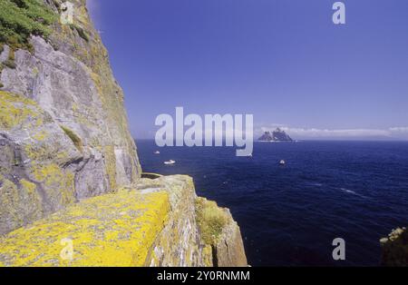 Scogliere rocciose che si affacciano sul mare e su un'isola lontana, vista delle isole Skellig, Ring of Kerry, Irlanda, Europa Foto Stock