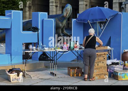 Modello di Plateosaurus con mercato delle pulci sul cartello di Bochum sulla piazza del municipio, Dino City III, Bochum, regione della Ruhr, Renania settentrionale-Vestfalia, Germania, EUR Foto Stock