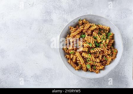 Pasta al sugo, pasta con carne macinata, fondo grigio, pasta fatta in casa, fusilli, non c'è gente Foto Stock