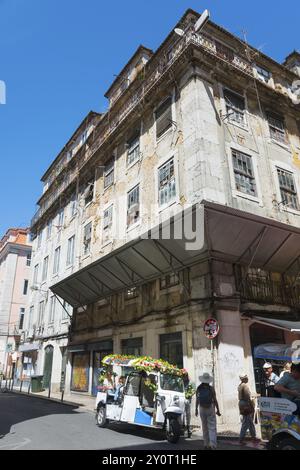 Edificio storico fatiscente con un tuk-tuk su una strada sotto un cielo azzurro, Rua Nova do Carvalho, Lisbona, Lisbona, Portogallo, Europa Foto Stock