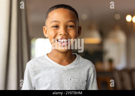 Ragazzo sorridente in camicia casual in piedi in casa, guardando la macchina fotografica Foto Stock