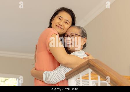 Sorridente e abbracciante, nonna asiatica e nipote condividono un caldo momento a casa Foto Stock