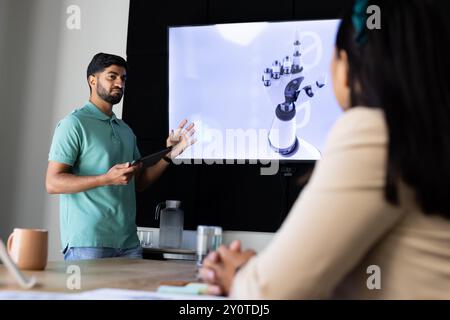 Presentazione del design robotico a mano, uomo indiano che usa un tablet in una moderna riunione d'ufficio Foto Stock