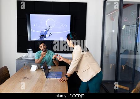 Parliamo di tecnologia robotica, colleghi che collaborano in un ufficio moderno con un notebook Foto Stock