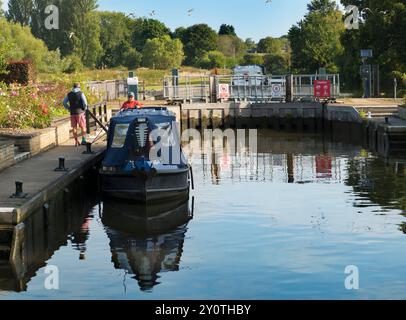 Casa galleggiante che passa attraverso Sandford Lock sulla Tmames, in un bel giorno di fine estate. L'area intorno alla chiusa S è un luogo molto apprezzato per chi pratica jogging, a piedi Foto Stock