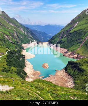 Austria - lago verde di montagna con diga vicino a Grossglokner. Diga del Mosserboden e vette alpine sullo sfondo . Vista panoramica di Stausee Wasserfallboden Foto Stock