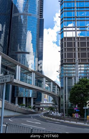 Hong Kong, Cina - 3 luglio 2024: Una strada cittadina di Hong Kong con un ponte pedonale su una strada curva. Foto Stock