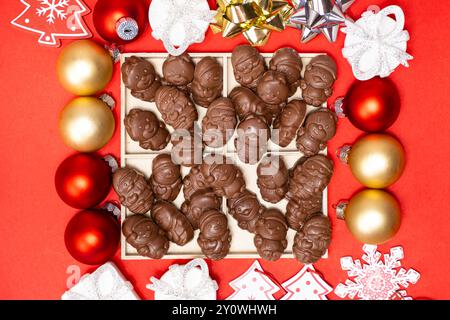 Cioccolatini a forma di figure natalizie sulla vista dall'alto su sfondo rosso Foto Stock