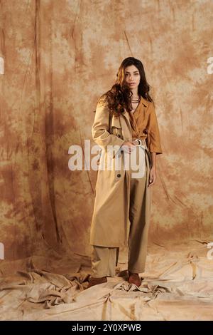 Una giovane donna sfoggia il suo chic look autunnale, combinando eleganza e comfort in un caldo ambiente da studio. Foto Stock