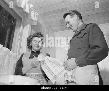 Effettivo 01- 1951: La grande avventura. La signorina Mabel Melrose di Preston in Australia e il tenente Audun Fristad di Terningmoen avevano inviato una corrispondenza per 10 mesi quando decisero che avrebbe attraversato l'oceano per sposarlo. Non si erano mai visti, scrivevano solo lettere lunghe e teneri, quindi la decisione che hanno preso è stata piuttosto audace. Quanto è divertente lavare i piatti insieme quando si è appena sposati e avere una nuova cucina! Se solo tutti i mariti facessero un sorriso quando devono aiutare le loro mogli con i piatti, CE ne sono molti che sospirano. Foto: Sverre A. Børretzen / A. Foto Stock