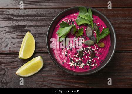 Gustoso hummus di barbabietola in ciotola su un tavolo di legno, vista dall'alto Foto Stock