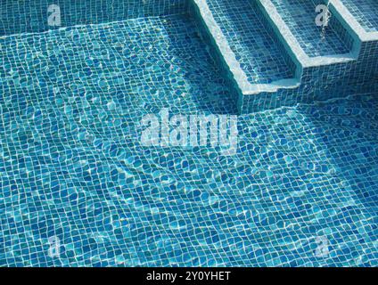 Vista dei gradini che scendono verso Una piscina di piccole piastrelle blu con Ripples in the Water, Regno Unito Foto Stock