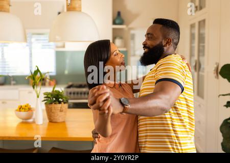 Coppia che ballano insieme in cucina, godendosi momenti di qualità a casa, in cucina Foto Stock