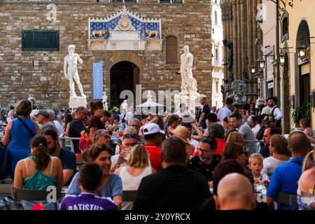 In Piazza della Signoria, di fronte all'ingresso di Palazzo Vecchio, i turisti siedono ai tavoli dei ristoranti, Settember 1, 2024. Il centro storico di Firenze, luogo di nascita del Rinascimento, attrae più di 10 milioni di turisti ogni anno ed è stato nominato Patrimonio dell'Umanità dall'UNESCO nel 1982. Foto Stock