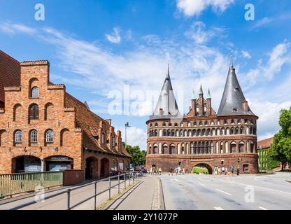 La porta Holsten (Holstentor) a Lübeck, in Germania, la porta occidentale della città medievale costruita nel 1464, con il Salzspeicher sulla sinistra. Foto Stock