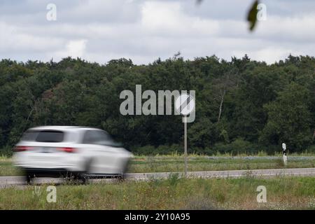 , Deutschland, Rheinland-Pfalz, Hatzenbühl, 04.09.2024, Ein weißes Auto fährt mit hoher Geschwindigkeit auf einer Landstraße, an der ein Verkehrsschi Foto Stock