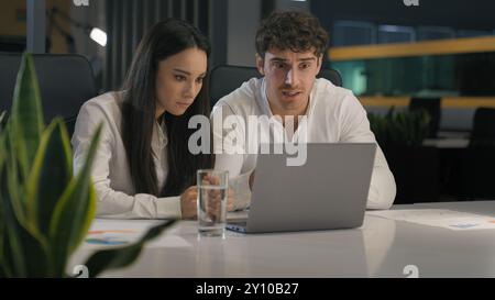 Colleghi di lavoro colleghi partner impiegati donna d'affari uomo d'affari uomo caucasico donna con laptop speranza successo triste sconvolto con Foto Stock