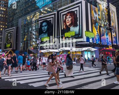 Orde di persone attraversano West 42nd Street sotto pubblicità per la Warner Bros. PicturesÕ ÒBeetlejuice BeetlejuiceÓ mercoledì 14 agosto 2024. Il film, diretto da Tim Burton, sarà distribuito il 6 settembre 2024 (© Richard B. Levine) Foto Stock