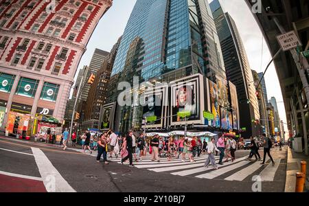Orde di persone attraversano West 42nd Street sotto pubblicità per la Warner Bros. PicturesÕ ÒBeetlejuice BeetlejuiceÓ mercoledì 14 agosto 2024. Il film, diretto da Tim Burton, sarà distribuito il 6 settembre 2024 (© Richard B. Levine) Foto Stock