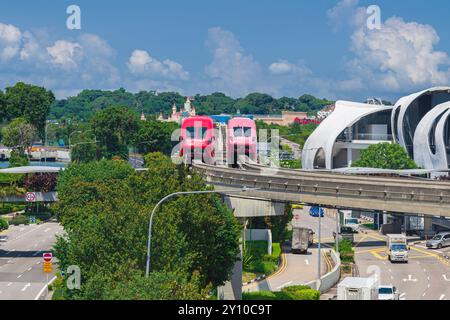 Singapore - 13 giugno 2024: Il Singapore Mass Rapid Train MRT corre su un binario che parte da Sentosa accanto a vivo. L'MRT è il secondo più vecchio, Busie Foto Stock