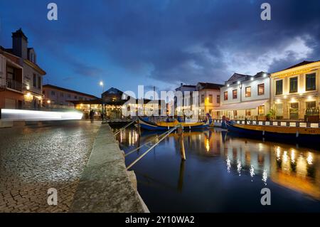 Vista della città di Aveiro, chiamata la Venezia del Portogallo, vista notturna del porto con il mercato, luci riflesse nell'acqua Foto Stock