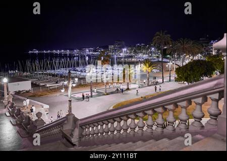 Sitges, Barcellona - 04 settembre 2024: Scena notturna Sitges di un porto turistico con barche attraccate, illuminazione ambientale e una scala con balaustre ornate. Foto Stock