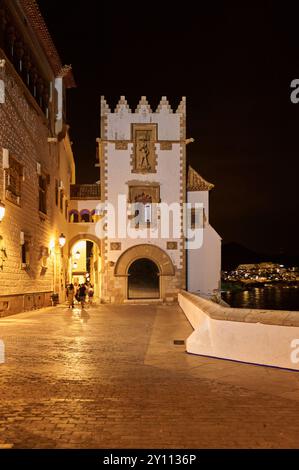 Sitges, Barcellona - 4 settembre 2024: Vista notturna del Palazzo Maricel a Sitges con una calda illuminazione che accentua la sua architettura gotica e la costa Foto Stock