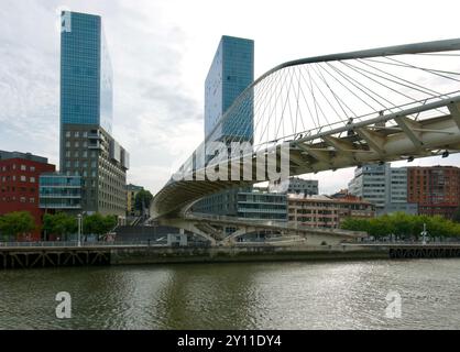 Le torri gemelle del complesso della porta di Isozaki e il ponte pedonale Zubizuri ad arco legato sul fiume Nerbiol Bilbao Paesi Baschi Euskadi Spagna Foto Stock