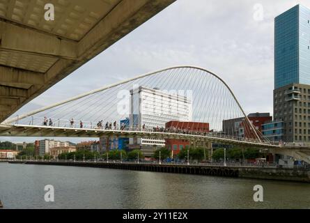 Le torri gemelle del complesso della porta di Isozaki e il ponte pedonale Zubizuri ad arco legato sul fiume Nerbiol Bilbao Paesi Baschi Euskadi Spagna Foto Stock