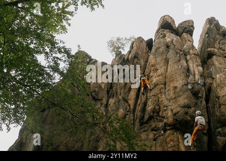 Sokoliki, Polonia. 31 agosto 2024. Gli scalatori sono visti salire la parete rocciosa nel settore di Sukiennice, con un scalatore libero visibile a sinistra, nella regione di arrampicata Sokoliki nel Voivodato della bassa Slesia, nel sud-ovest della Polonia. La regione di arrampicata Sokoliki (conosciuta anche come Soko'y o GÃ³ry Sokole) è molto popolare tra gli scalatori. La regione si trova nel sud-ovest della Polonia, a circa 15 km dalla città di Jelenia GÃ³ra. Durante la stagione calda, scalatori polacchi e stranieri visitano la regione per scalare le falesie di granito. (Immagine di credito: © Volha Shukaila/SOPA Images via ZUMA Press Foto Stock