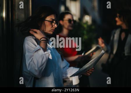Giovani donne d'affari che esaminano documenti all'aperto durante una pausa Foto Stock