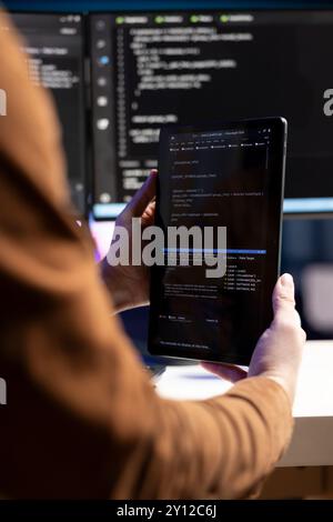 Programmatore di telelavoro che progetta e sviluppa applicazioni software tramite tablet. Amministratore IT che implementa e gestisce i sistemi aziendali utilizzando dispositivi portatili, primo piano Foto Stock