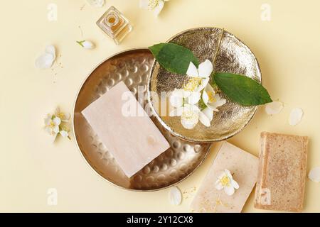 Composizione con barrette di sapone, olio essenziale e splendidi fiori di gelsomino su sfondo colorato Foto Stock