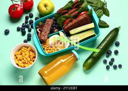 Frutta, verdura e pranzo al sacco con cibo gustoso su sfondo turchese Foto Stock