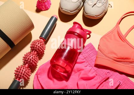 Set di attrezzature sportive, vestiti e bottiglia d'acqua su sfondo colorato, primo piano Foto Stock