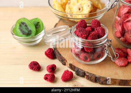 Ciotole e vasetti di frutta e bacche disidratate diverse su fondo di legno Foto Stock