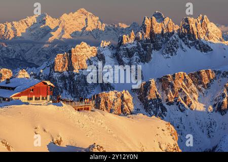 Rifugio al tramonto sulla neve di fronte alle aspre montagne, Rifugio Lagazuoi, Dolomiti, Italia, Europa Foto Stock