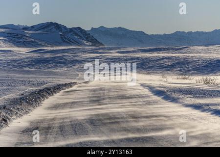 Neve su strada ghiaia in inverno, Dalton Highway, Brooks Range, Alaska, Stati Uniti, nord America Foto Stock