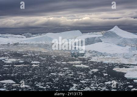 Iceberg in un fiordo contro un cielo nuvoloso, estate, Ilulissat Icefjord, Disko Bay, Groenlandia occidentale, Groenlandia, Nord America Foto Stock