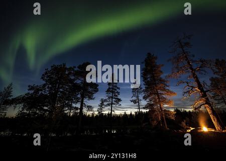 Uomo la sera in un bivacco con falò, Lapponia, Svezia, Scandinavia, Europa Foto Stock