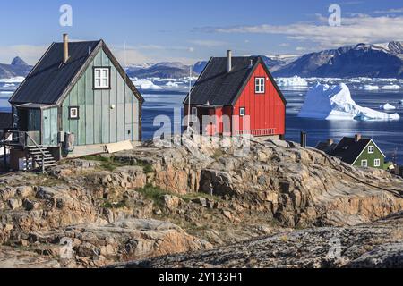 Tipiche case groenlandesi di fronte agli iceberg, insediamento Inuit, estate, sole, Uummannaq, Groenlandia occidentale, Groenlandia, Nord America Foto Stock