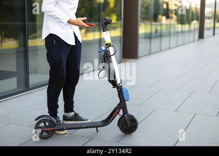 Giovani e casual uomo d affari di equitazione scooter elettrico in città Foto Stock