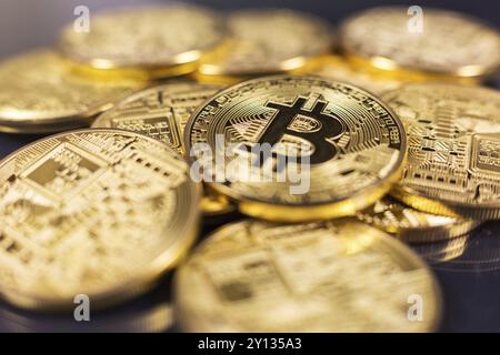 Pila di bitcoins giacente sulla lucida superficie scura Foto Stock