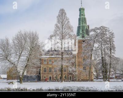 Castello in inverno, circondato da alberi innevati e un lago ghiacciato, Raesfeld, muensterland, germania Foto Stock