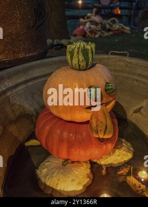 Zucca creativa con incisioni e lume di candela in un contenitore metallico con acqua di notte, borken, muensterland, germania Foto Stock